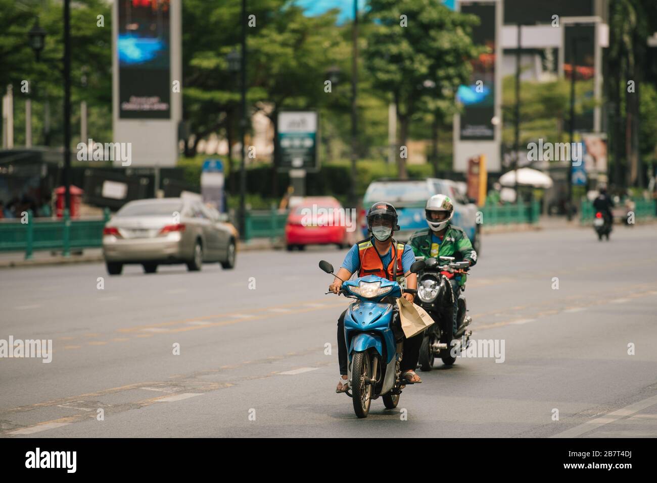 Moto chauffeur de taxi porte un masque et des lecteurs sur Ratchadamri Road, Bangkok, Thaïlande. Les rues sont calmes en raison de l'épidémie de virus corona. Banque D'Images