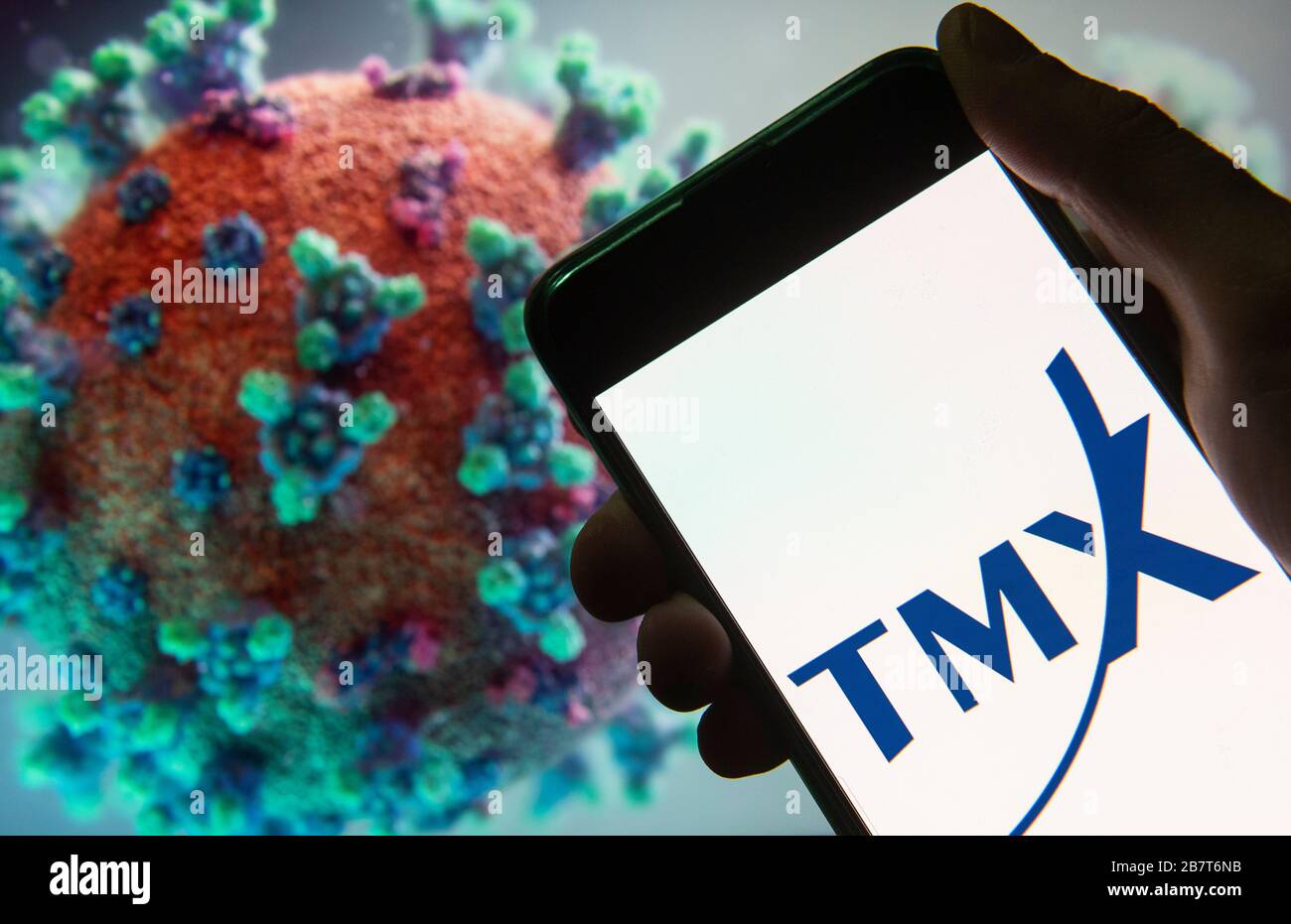 Chine. 18 mars 2020. Dans cette illustration photo, la société canadienne de services financiers, Translation Memory Exchange, TMX, logo affiché sur un smartphone avec un modèle d'ordinateur du coronavirus COVID-19 en arrière-plan. Crédit: SOPA Images Limited/Alay Live News Banque D'Images