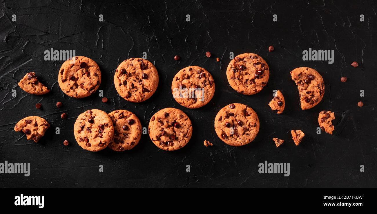 Les cookies aux pépites de chocolat panoramiques sur un fond noir, tiré du dessus, une couche plate Banque D'Images