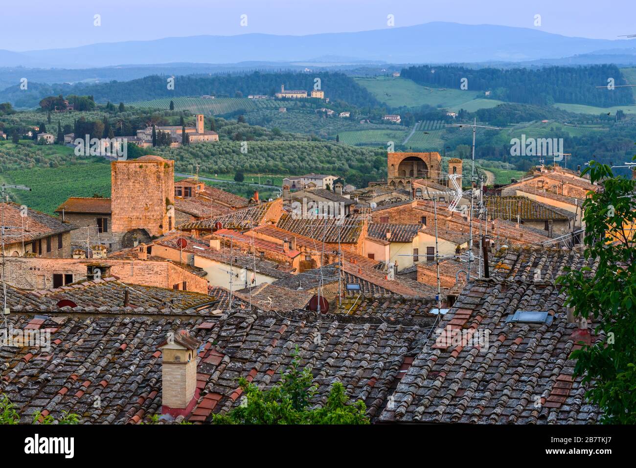 Toits de San Gimignano, campagne toscane avec collines ondulantes et Santa Maria Assunta a Monte Oliveto Minore de Parco della Rocca, San Gimignano. Banque D'Images