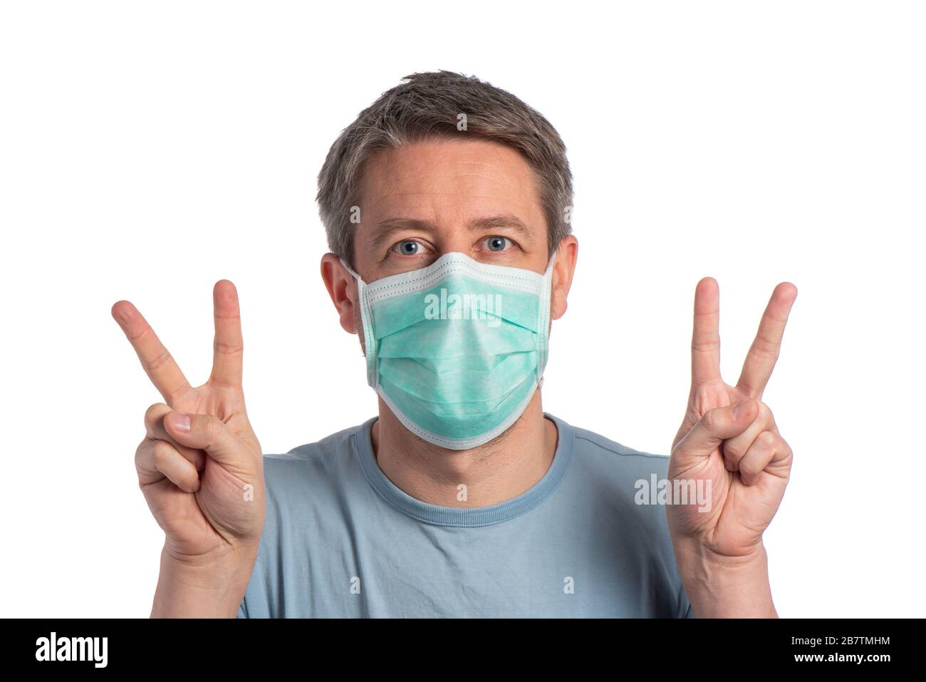 Homme caucasien portant un masque de protection et faisant signe de vistory avec des gants de protection sur un fond blanc Banque D'Images