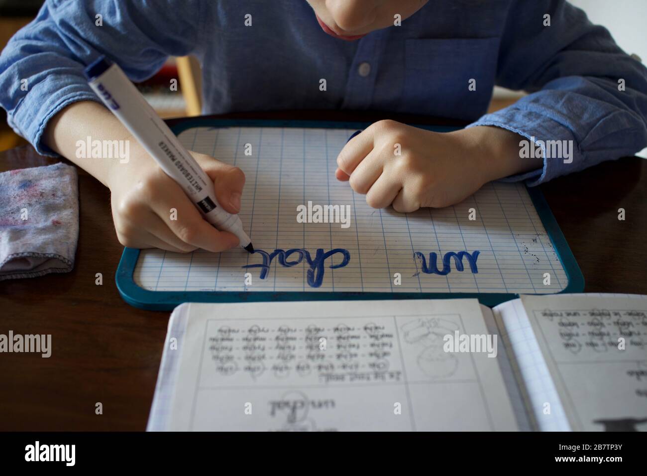 Enfant ayant été homeschoolé pendant la pandémie de Coronavirus - apprendre à écrire Banque D'Images
