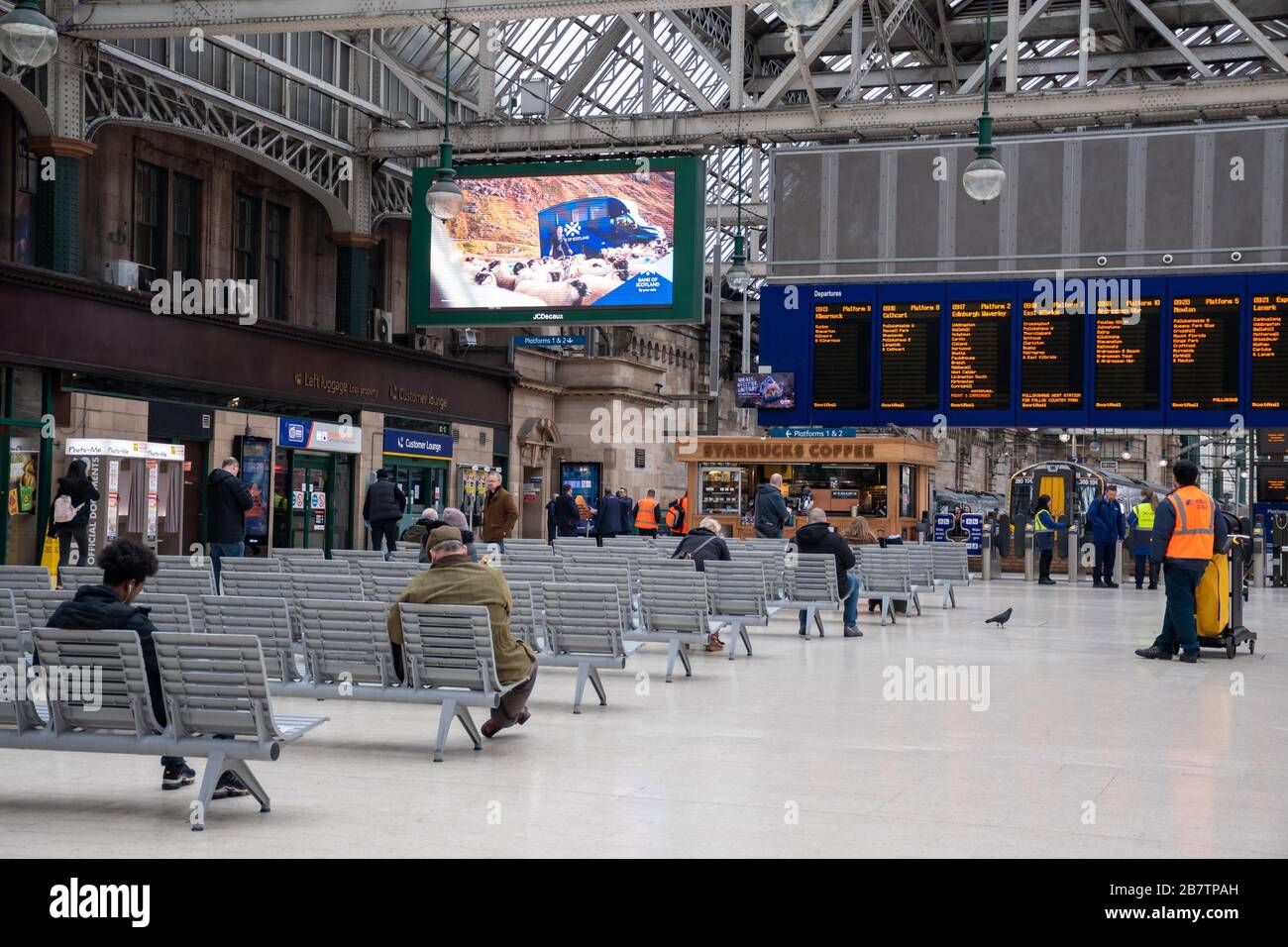 Distanciation sociale dans une station centrale tranquille de Glasgow à l'heure de pointe du matin pendant l'éclosion de Coronavirus. Banque D'Images