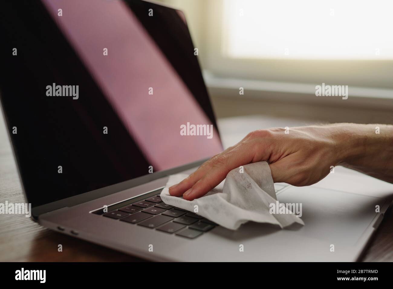 Nettoyage du clavier de l'ordinateur portable à l'aide d'un chiffon humide sur le lieu de travail. Hygiène personnelle Banque D'Images