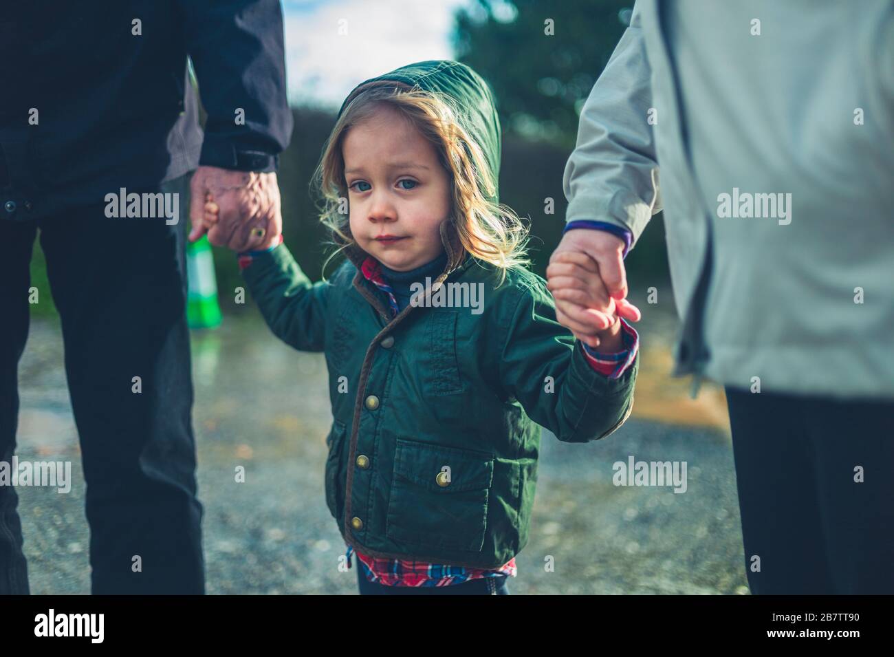 Un peu d'enfants d'âge préscolaire marchaient main dans la main avec ses grands-parents dehors en hiver Banque D'Images