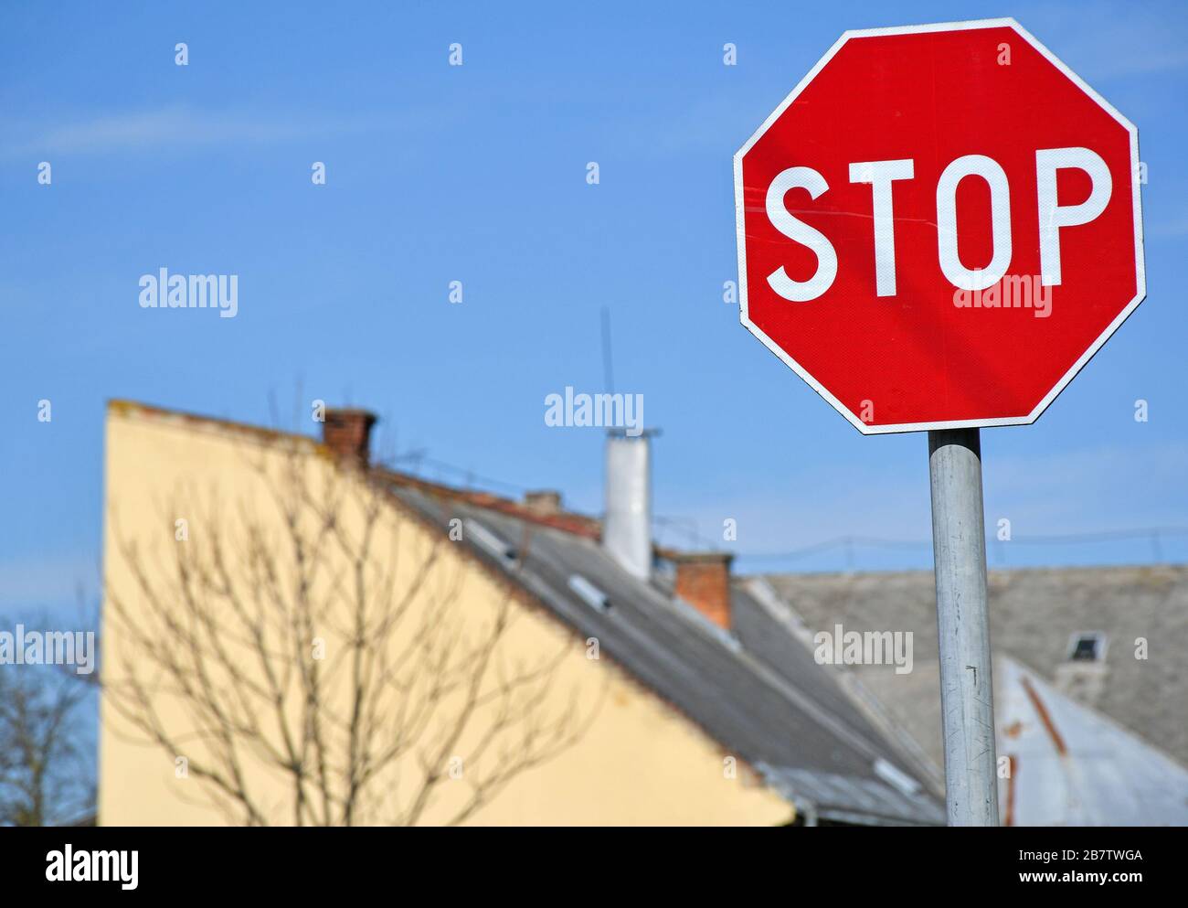 Panneau d'arrêt contre le ciel bleu en face d'un bâtiment Banque D'Images
