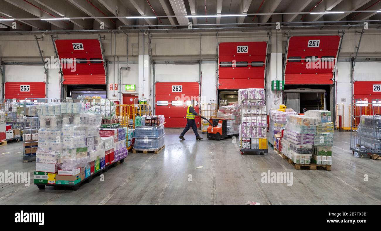 Eitting, Allemagne. 18 mars 2020. Un homme pousse un transpalette chargé de marchandises à travers le terminal de chargement de l'entrepôt central REWE South. Crédit: Peter Knelove/dpa/Alay Live News Banque D'Images