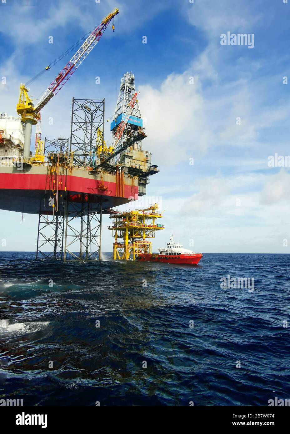 le navire de soutien offshore se trouve à 500 mètres de la nouvelle plate-forme pétrolière pour recevoir du fret par l'opérateur de grue Banque D'Images