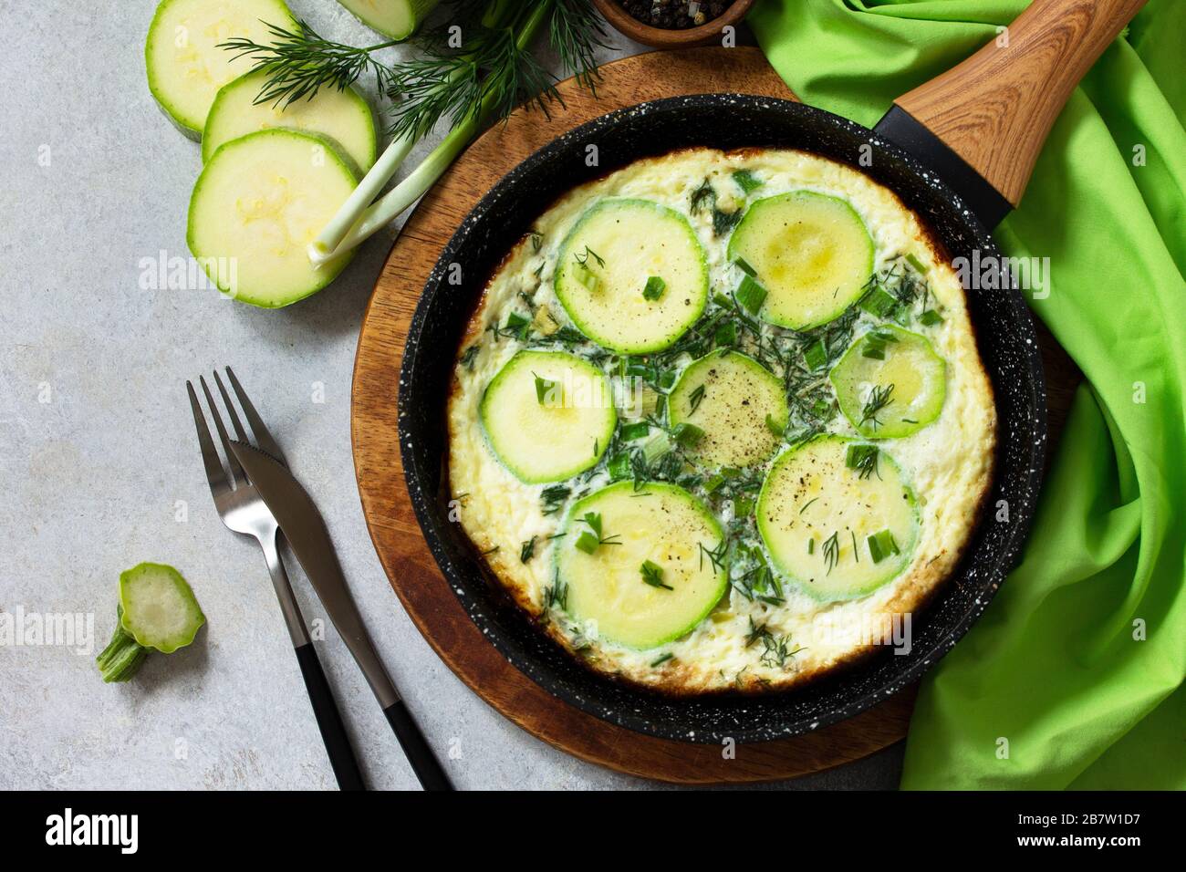 Petit déjeuner. Omelette d'été avec courgettes et herbes sur une table en pierre ou en ardoise. Vue sur le dessus plat. Espace de copie. Banque D'Images