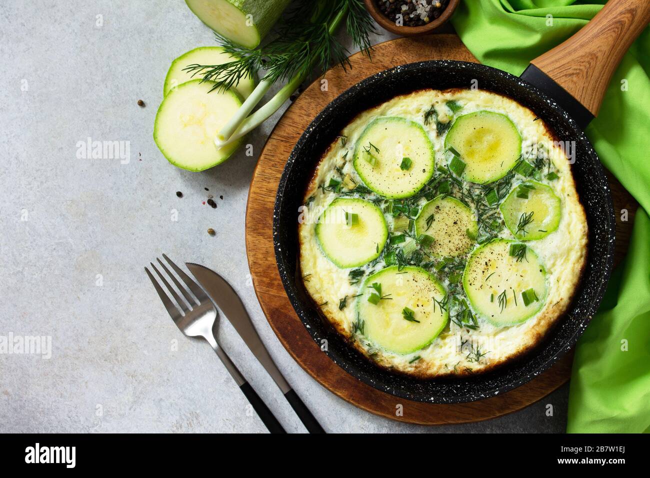 Petit déjeuner. Omelette d'été avec courgettes et herbes sur une table en pierre ou en ardoise. Vue sur le dessus plat. Espace de copie. Banque D'Images