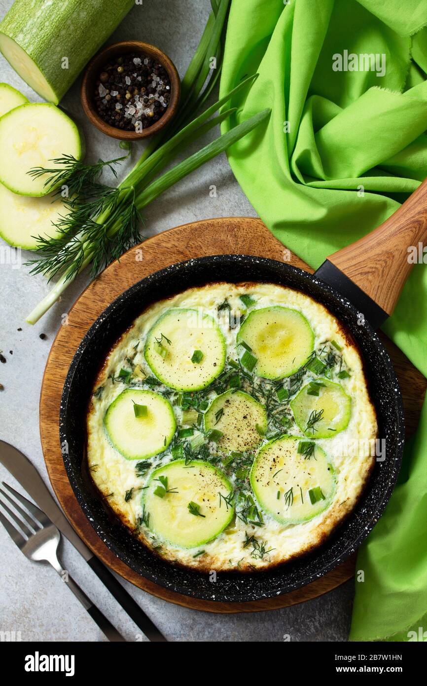 Petit déjeuner. Omelette d'été avec courgettes et herbes sur une table en pierre ou en ardoise. Vue sur le dessus plat. Banque D'Images