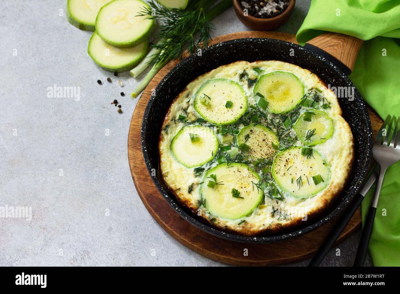 Petit déjeuner. Omelette d'été avec courgettes et herbes sur une table en pierre ou en ardoise. Espace de copie. Banque D'Images