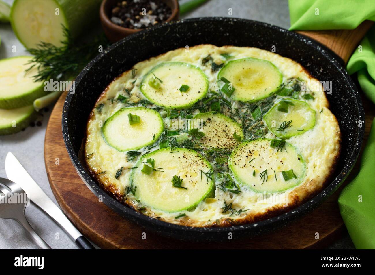 Petit déjeuner. Omelette d'été avec courgettes et herbes sur une table en pierre ou en ardoise. Banque D'Images