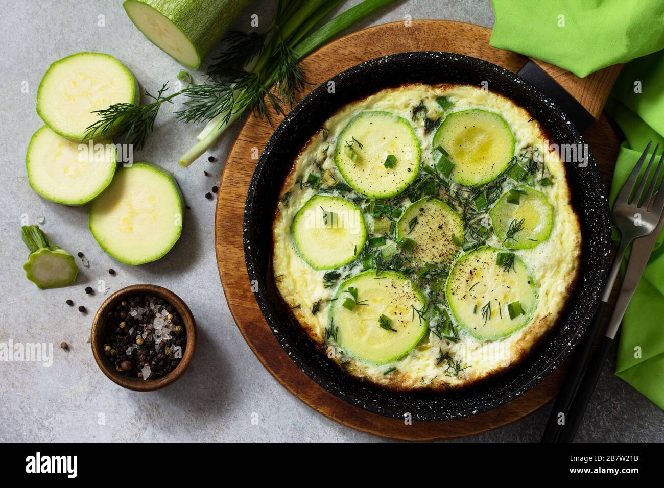 Petit déjeuner. Omelette d'été avec courgettes et herbes sur une table en pierre ou en ardoise. Vue sur le dessus plat. Banque D'Images