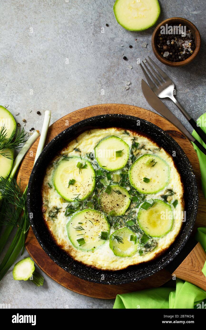 Petit déjeuner. Omelette d'été avec courgettes et herbes sur une table en pierre ou en ardoise. Vue sur le dessus plat. Espace de copie. Banque D'Images