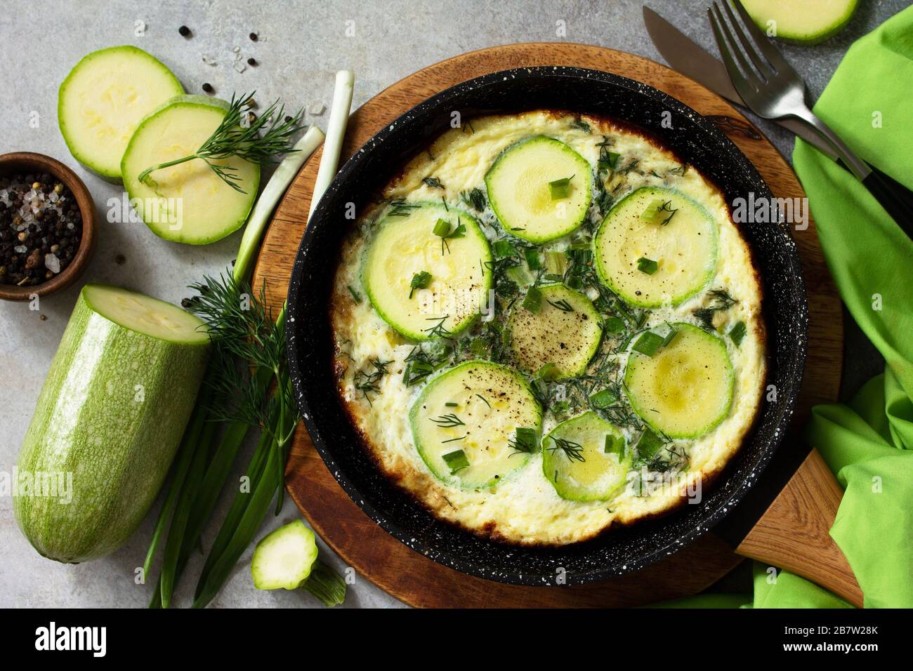 Petit déjeuner. Omelette d'été avec courgettes et herbes sur une table en pierre ou en ardoise. Vue sur le dessus plat. Banque D'Images
