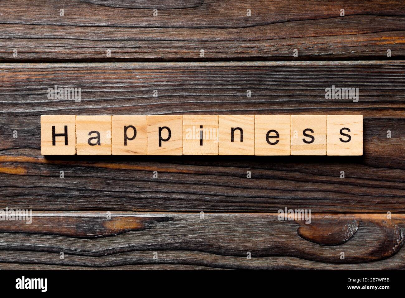 Mot de bonheur écrit sur le bloc de bois. Texte de bonheur sur table en bois pour votre dessing, concept de vue de dessus. Banque D'Images