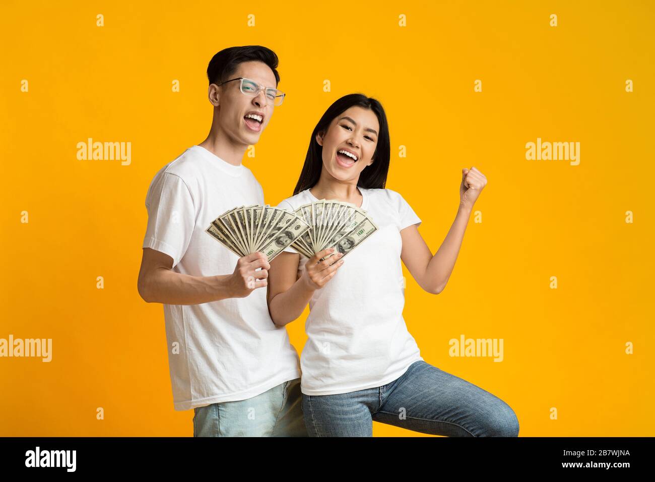 Jeune homme et femme asiatique riche qui détient de l'argent Banque D'Images