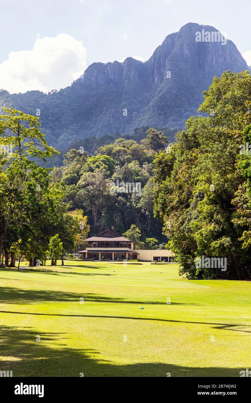 Vue sur le 18ème fairway depuis le tee vers le vert d'entraînement et le clubhouse assis sous la montagne Gunung Mat Cincang, la Rainforest Golf co Banque D'Images
