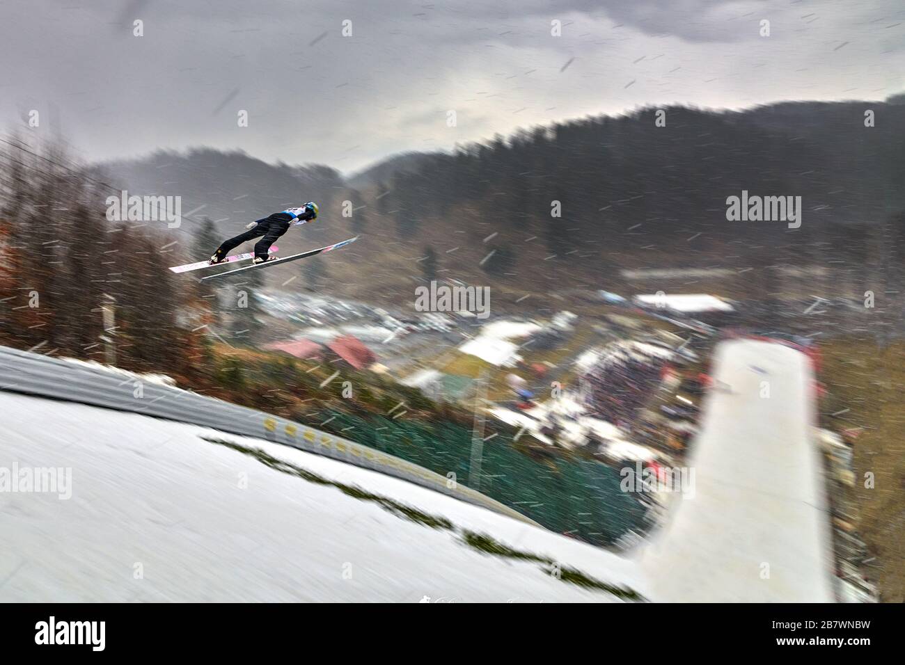 Rasnov, Roumanie - 20-22ème février 2020: Un cavalier inconnu componte pour gagner l'événement de saut à ski de la coupe du monde de Man à Rasnov, Roumanie en flou de mouvement, B Banque D'Images