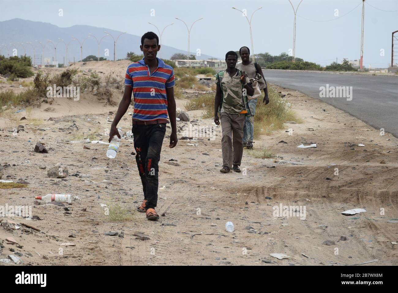 Aden, Yémen. 18 mars 2020. Les immigrants africains se dirigent vers la périphérie ouest de la ville portuaire sud d'Aden, Yémen, le 18 mars 2020. Le gouvernement du Yémen a déclaré un certain nombre de mesures de précaution pour tenter de freiner le déclenchement du coronavirus dans le pays arabe ravagé par la guerre. En dépit de ces mesures, yéménites a déclaré que des milliers d'immigrants et de demandeurs d'asile africains continuent de se bloquer dans le pays par le biais de postes frontière illégaux, car l'autorité sur les postes terrestres, aériens et maritimes du Yémen est fracturée entre le gouvernement soutenu par l'Arabie saoudite et le crédit Iranii : Xinhua/A. Banque D'Images
