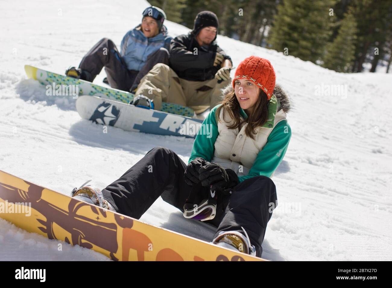 Jeunes surfeurs assis dans la neige Banque D'Images