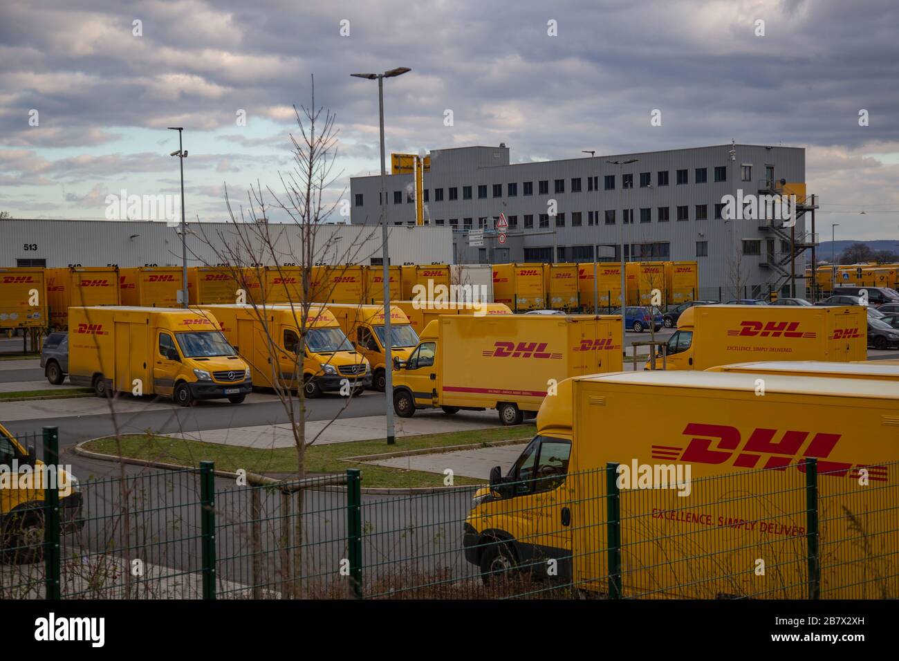 Neuwied, Allemagne - 07 mars 2020: Les fourgonnettes DHL devant un dépôt DHL et un immeuble de bureaux. DHL est un leader mondial de la logistique Banque D'Images