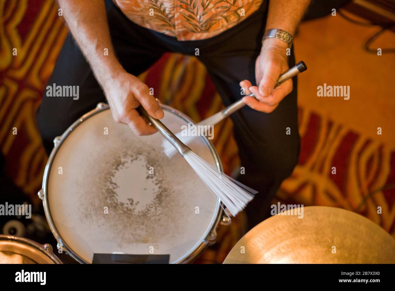 Homme jouant un tambour avec des bâtons de tambour à plumes. Banque D'Images