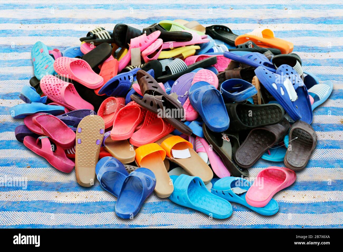 Piles de chaussures vendues dans diverses combinaisons de couleurs marché  rural, sandales, chaussures décontractées, vieux Photo Stock - Alamy