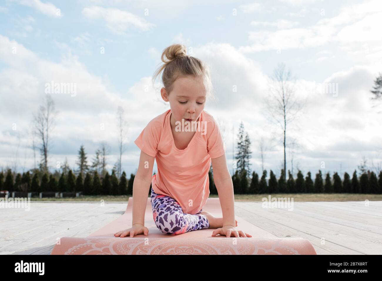 jeune fille faisant du yoga s'étirant dans son arrière cour à la maison Banque D'Images