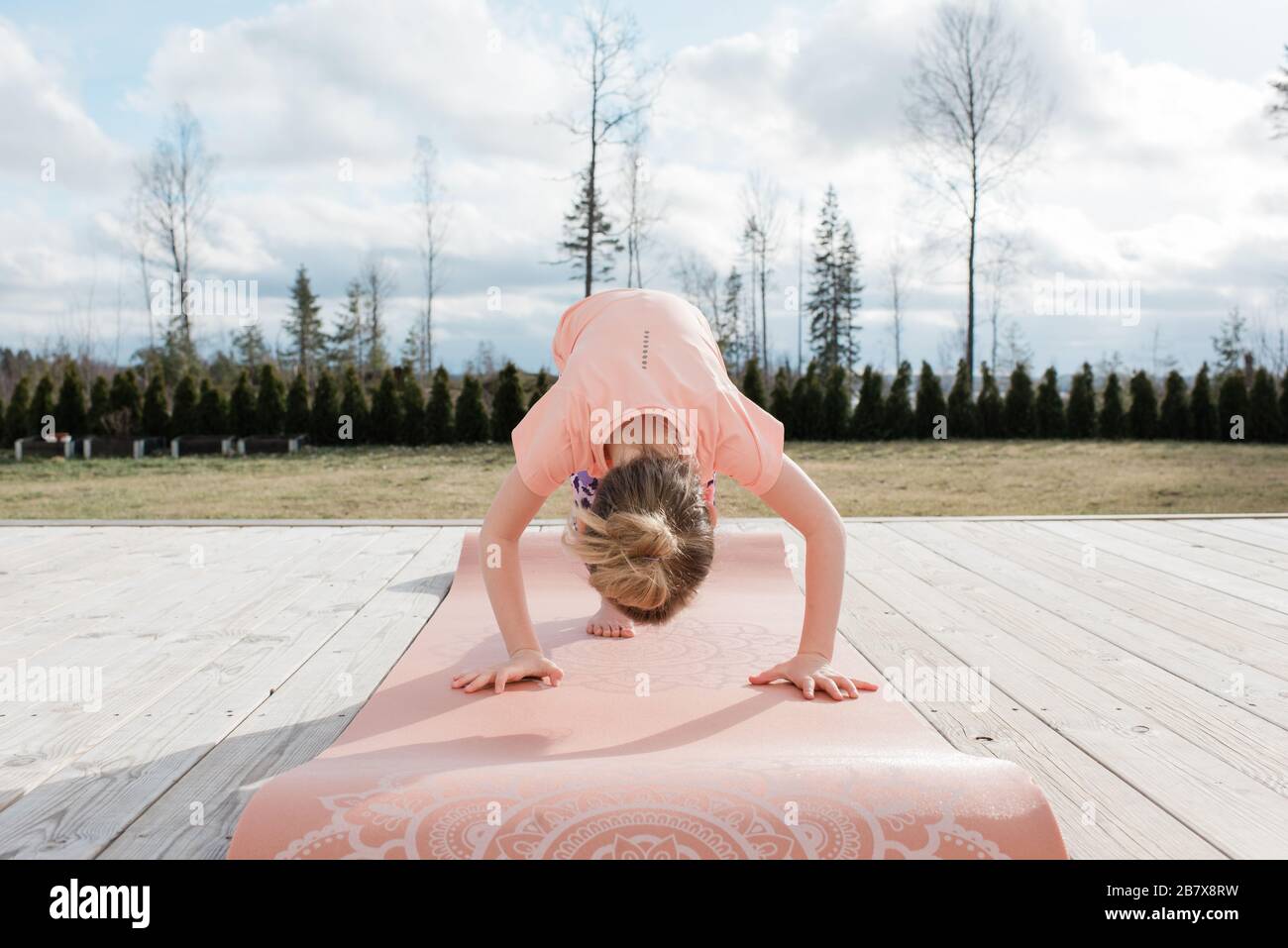 jeune fille faisant du yoga à l'extérieur dans son arrière cour à la maison Banque D'Images