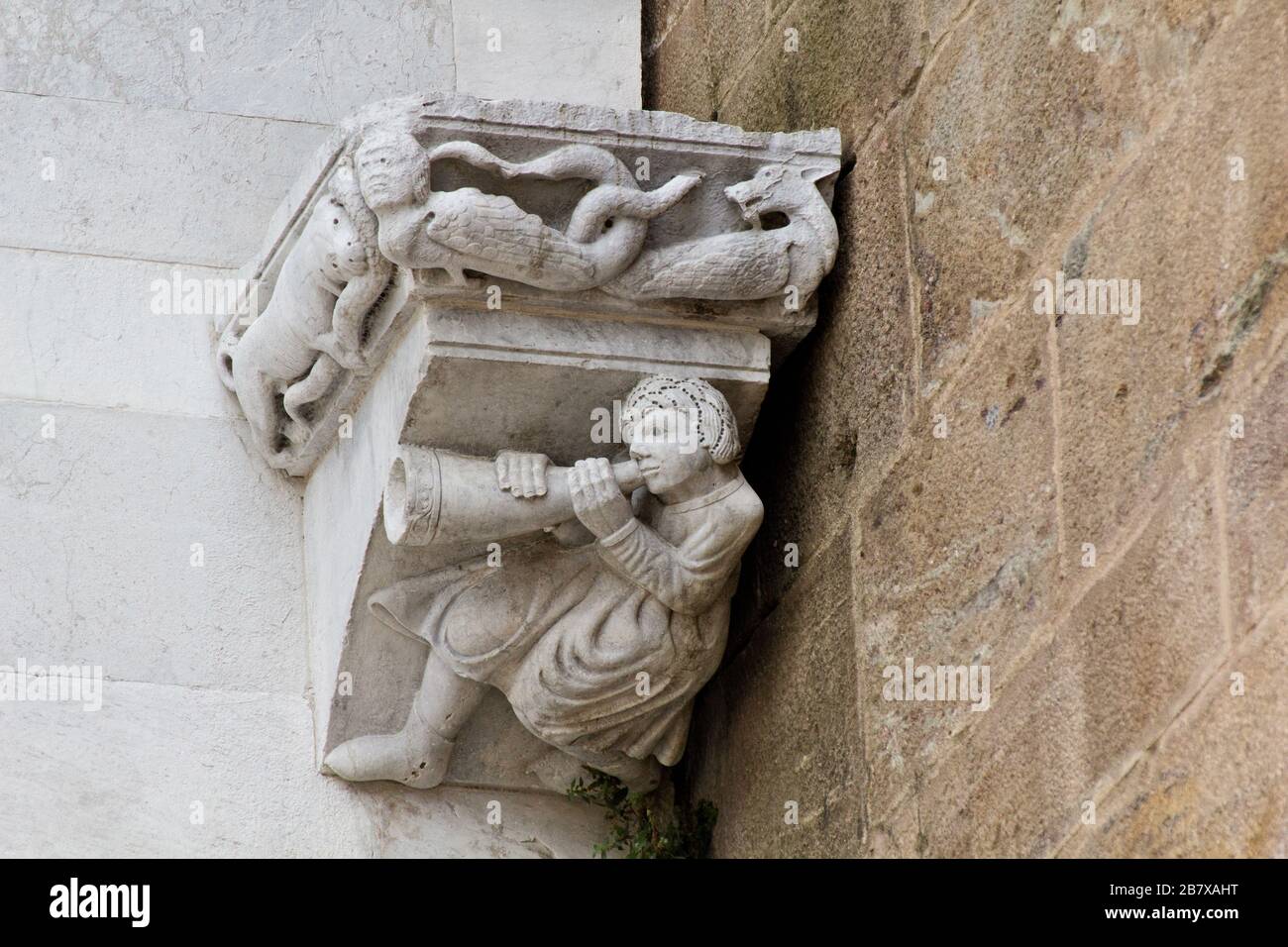 Un homme médiéval jouant une corne sous le regard de diverses créatures mythologiques féroces - façade de la cathédrale de Sain Martin, - Lucca, Toscane, Italie Banque D'Images