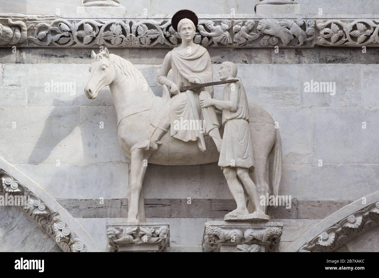 La statue médiévale de Saint Martin et le mendiant sur la façade de la cathédrale de Lucques, Toscane, Italie Banque D'Images