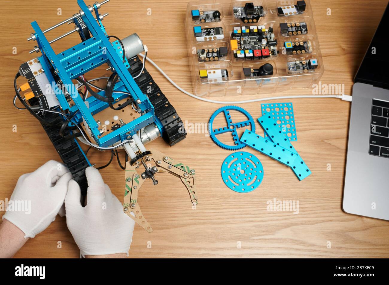 Robot connecté à l'ordinateur sur une table en bois au-dessus de la vue du dessus Banque D'Images