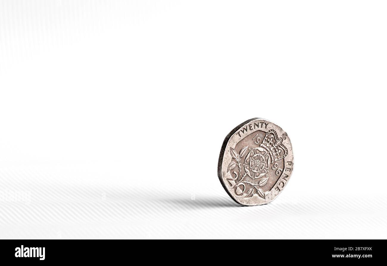 1996 pièce de monnaie de vingt penny équilibrée sur le côté avec la queue montrant sur un fond blanc. Paysage avec espace libre sur le côté gauche de l'image. Banque D'Images