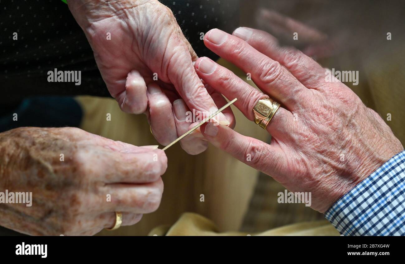 Couple de personnes âgées dans leurs années quatre-vingt couper les ongles les uns les autres à la maison Banque D'Images