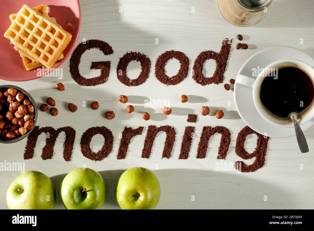 Bon matin café grains de grains de café inscription avec fond de table lumineux. Espace de copie pour les produits publicitaires et la décoration. Banque D'Images