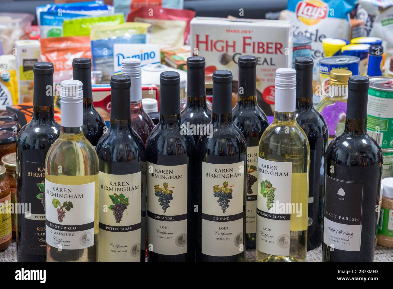 Morgantown, WV - 18 mars 2020: Sélection de produits d'épicerie pour le stockage à domicile pendant la quarantaine en raison de l'épidémie de Coronavirus avec accent sur les bouteilles de vin Banque D'Images