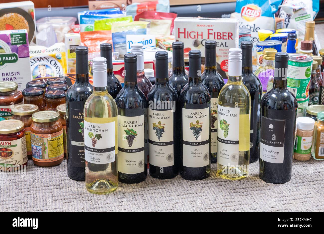 Morgantown, WV - 18 mars 2020: Sélection de produits d'épicerie pour le stockage à domicile pendant la quarantaine en raison de l'épidémie de Coronavirus avec accent sur les bouteilles de vin Banque D'Images