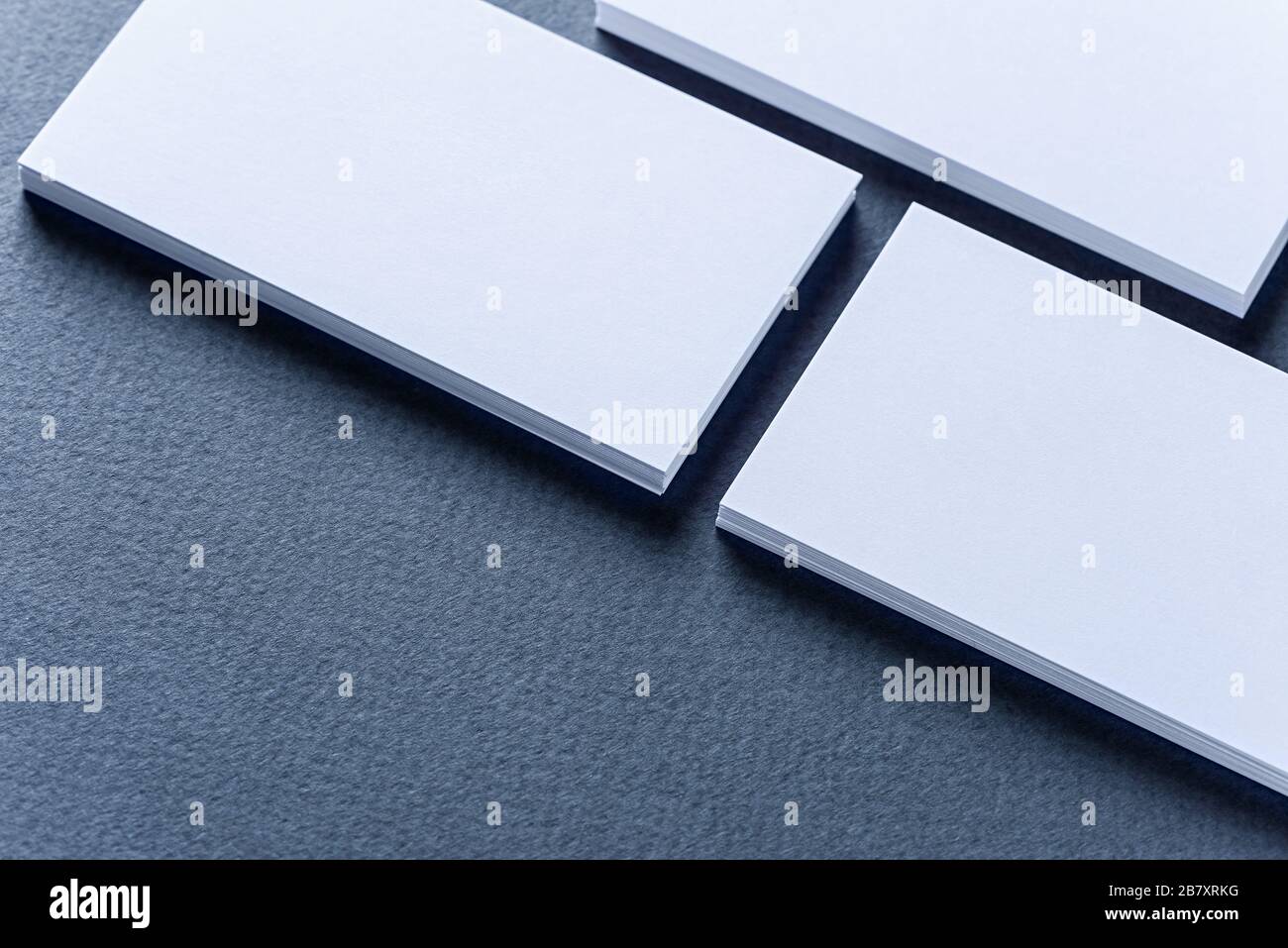 Maquette de piles de cartes de visite disposées en rangées sur un fond bleu. Banque D'Images