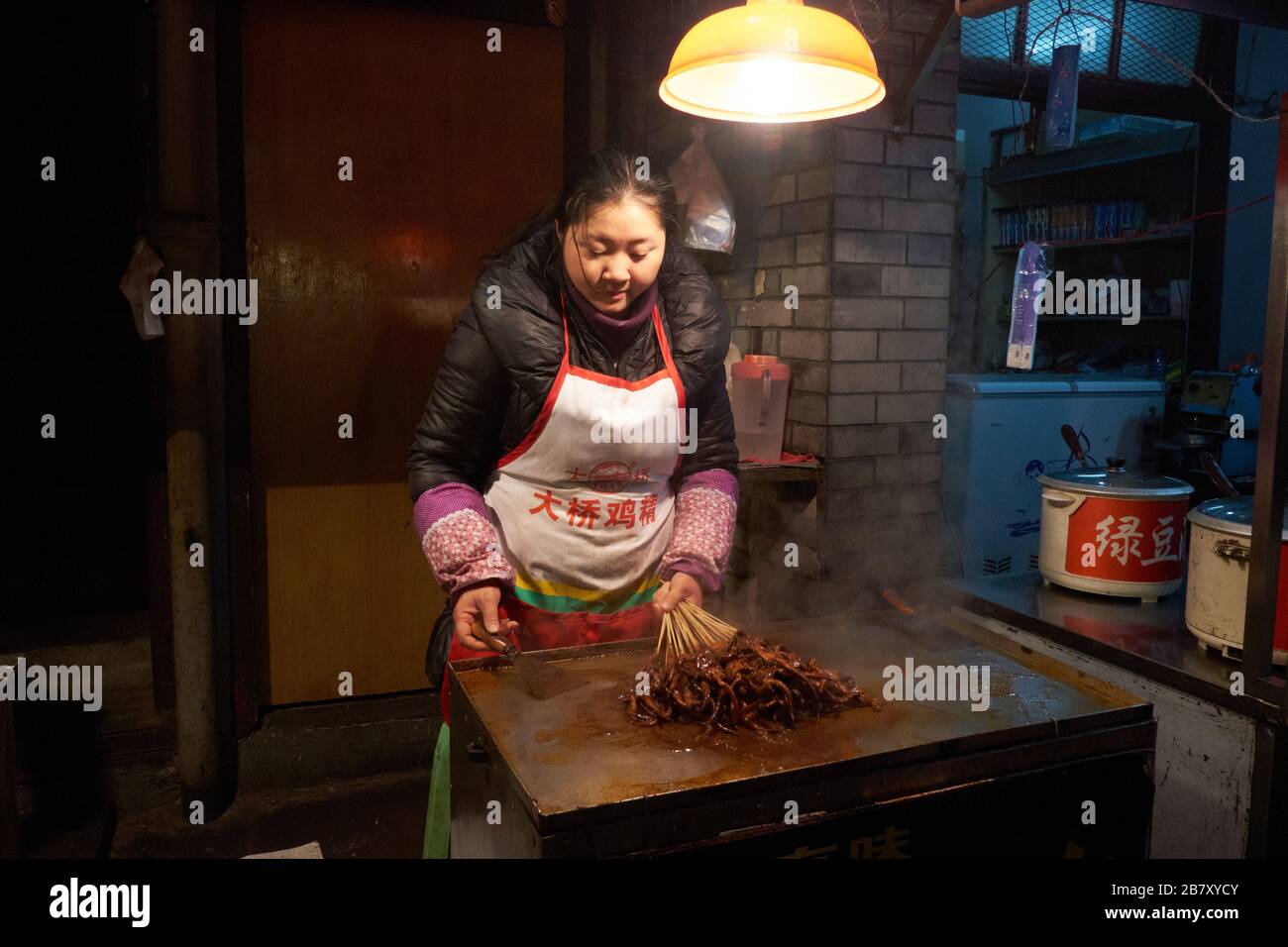 Wuhan, Chine dans la province de Hubei, tourné en 2013, montrant des stallporteurs préparant et servant des aliments cuits. Banque D'Images