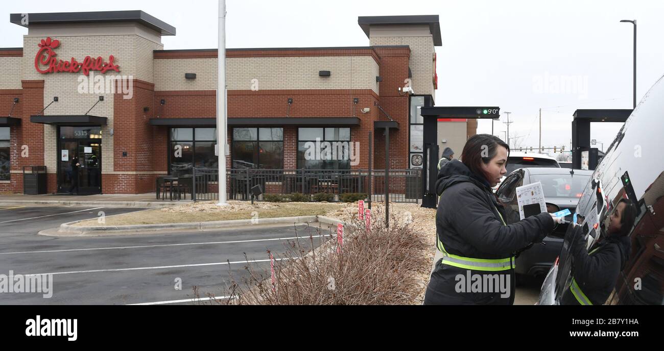 Mount Pleasant, Wisconsin, États-Unis. 18 mars 2020. Des voitures sont à votre disposition au déjeuner au restaurant Chick-fil-A pour un service en voiture dans le village de Mount Pleasant (près de racine), Wisconsin, le mercredi 18 mars 2020. Le restaurant a fermé sa salle à manger cette semaine. Les employés du restaurant ont pris des commandes côté voiture pour accélérer le processus. Crédit: Mark Hertzberg/ZUMA Wire/Alay Live News Banque D'Images