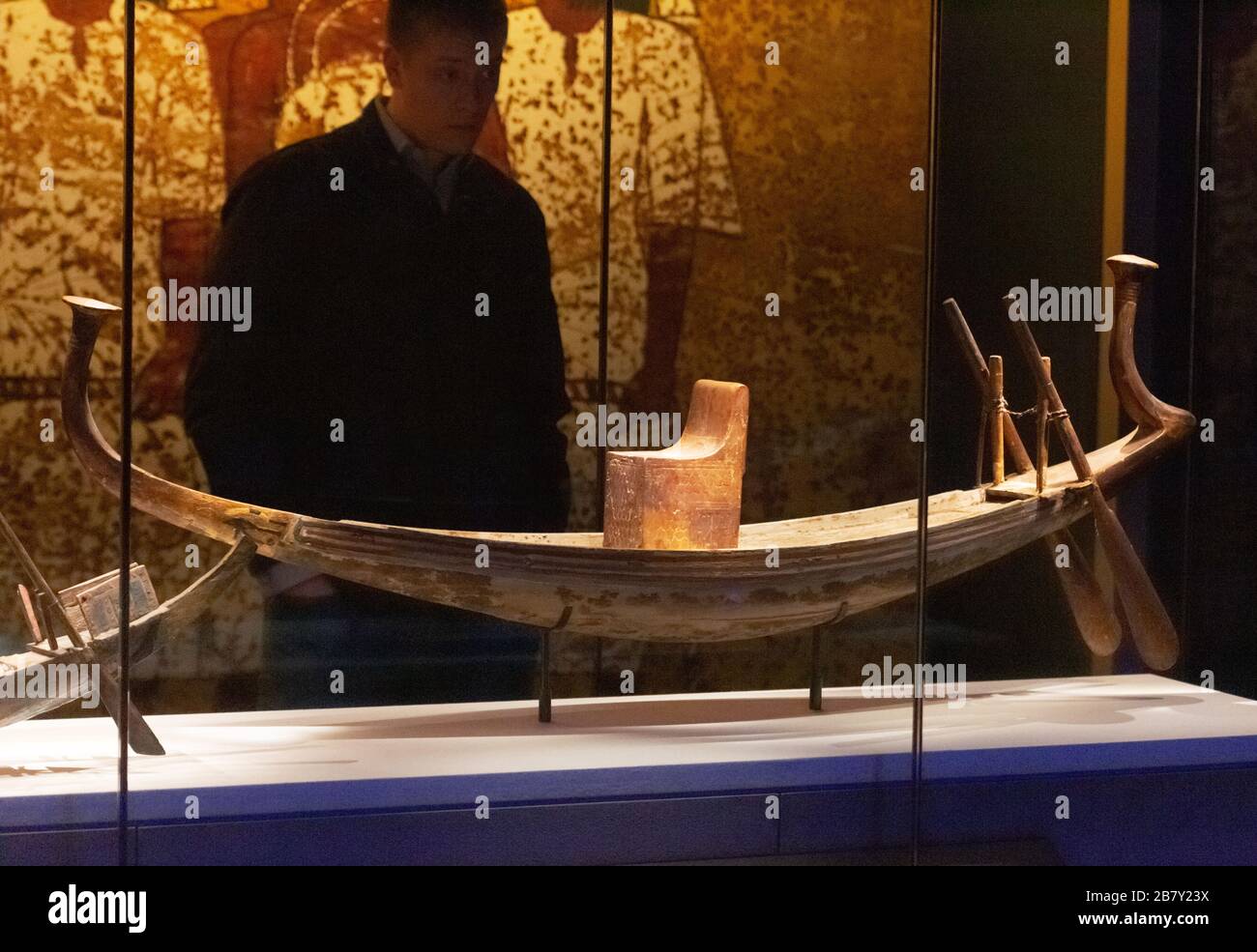 Un visiteur de l'exposition Toutankhamun regardant un modèle de bateau solaire de la tombe de Toutankhamen, de l'Egypte ancienne; Saatchi Gallery Londres UK Banque D'Images Un visiteur de l'exposition Toutankhamun regardant un modèle de bateau solaire de la tombe de Toutankhamen, de l'Egypte ancienne; Saatchi Gallery Londres UK Banque D'Images