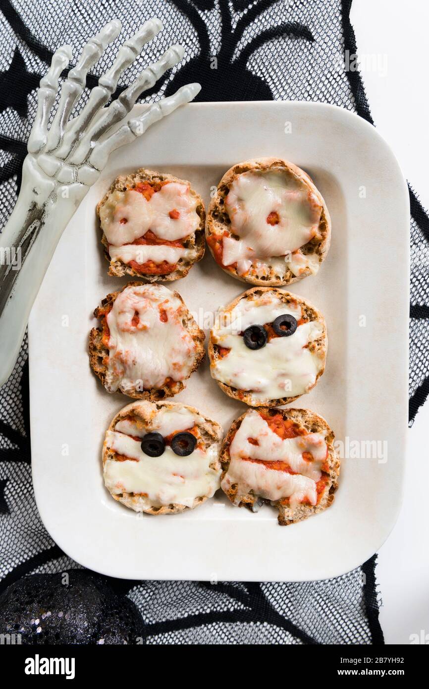 Assiette de mini pizzas et main de squelette d'Halloween Banque D'Images