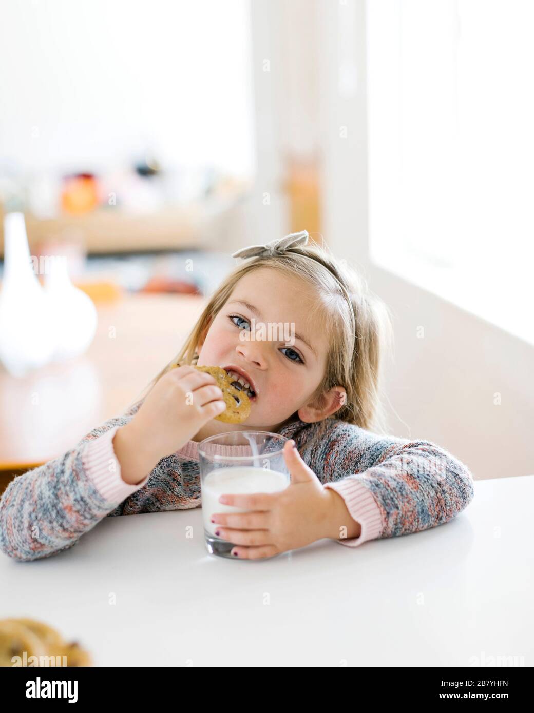 Girl eating lait et cookies Banque D'Images