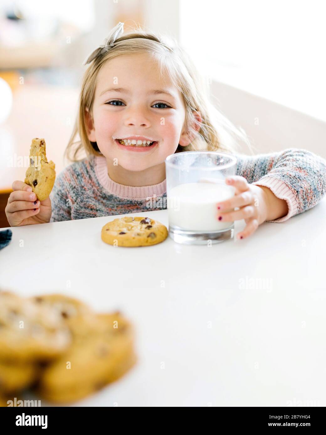 Girl eating lait et cookies Banque D'Images
