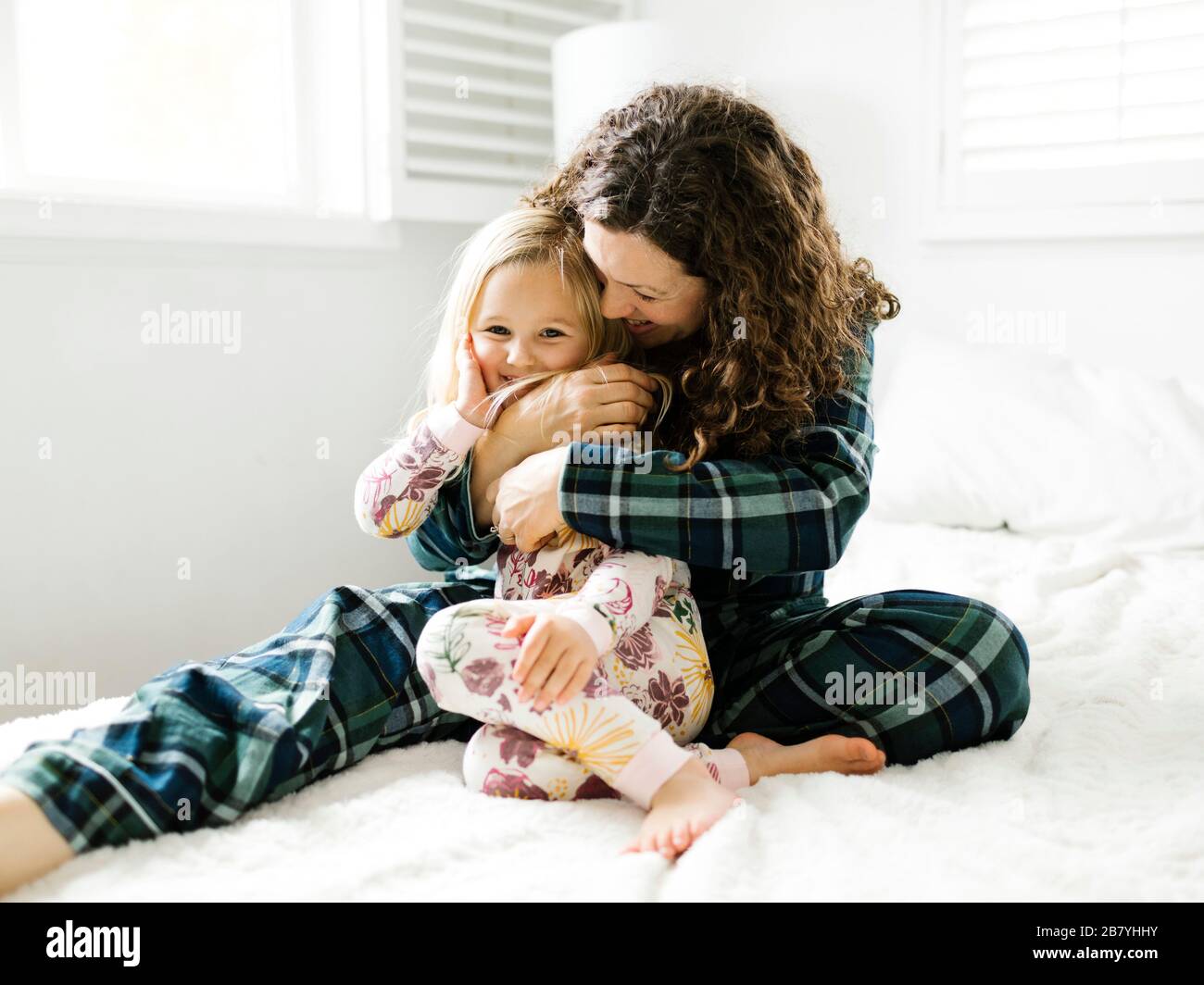 Mother and Daughter hugging on bed Banque D'Images