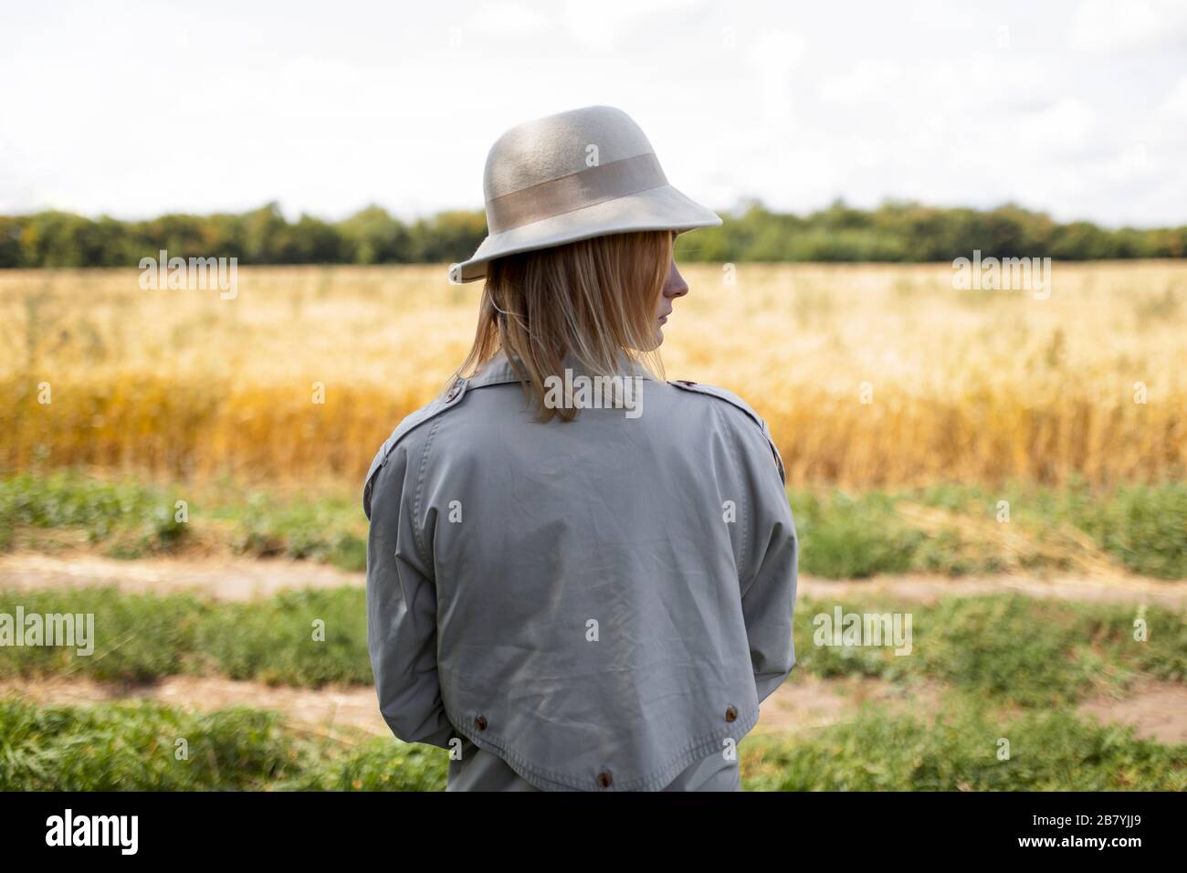 Jeune femme avec fedora dans le champ de blé Banque D'Images