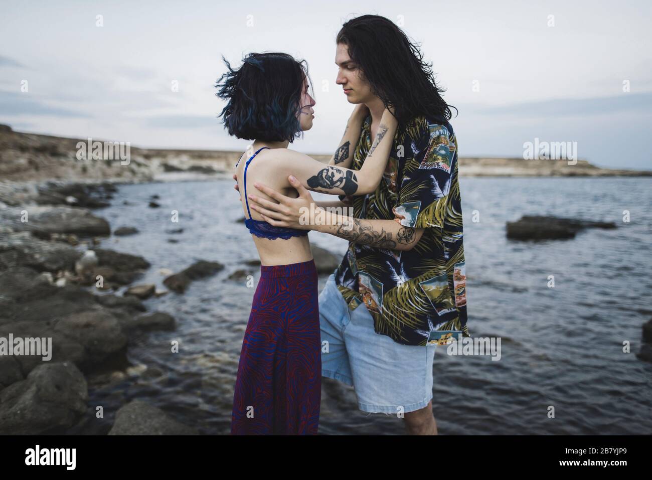 Jeune couple face à face sur la plage Banque D'Images