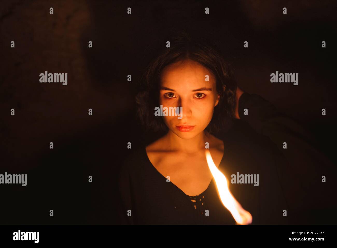 Jeune femme avec torche flamboyante la nuit Banque D'Images